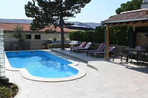 a swimming pool in a yard with a table and chairs at Apartments Tea Pag in Pag