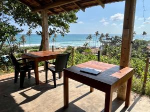 a table and chairs on a porch with a view of the beach at Sky Mountain Café with seaview in Weligama