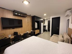 a room with a bed and a living room with a tv at Flat Praia Ponta de Campina in Cabedelo