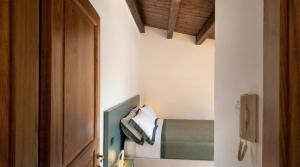 a small bedroom with a bed and a wooden door at Casa Ereva in Bagnoli Irpino