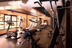 a gym with several treadmills and elliptical machines at DoubleTree by Hilton Nairobi in Nairobi