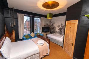 a bedroom with two beds and a tv in it at Cornerstone Manor Hotel in Sale