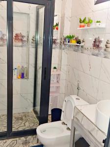 a bathroom with a toilet and a glass shower at Résidence Atlantis F2 avec balcon vue dégagée in Dakar +14 photos