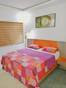 a bedroom with a bed with a checkered blanket at Résidence Atlantis F2 avec balcon vue dégagée in Dakar