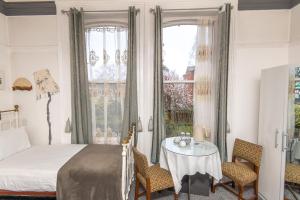 a bedroom with a bed and a table with chairs at Cornerstone Manor Hotel in Sale