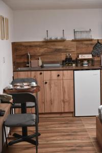 a kitchen with wooden cabinets and a table and a whiteboard at Lex Apartments KS in Prizren
