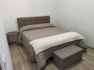 a bed in a room with a white wall at Salinelle Home in Paterno