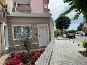 a house with a white door and flowers on the sidewalk at Apartment Ivan in Pomorie