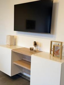 a white cabinet with a tv on a wall at Deck in Cuxhaven