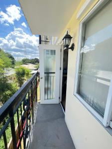 ein Balkon mit Tür und Blick auf das Meer in der Unterkunft Js Place at Arezzo Place Davao in Davao City