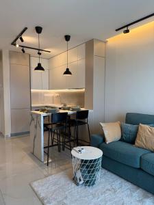 a living room with a blue couch and a kitchen at SEAFRONT 1BDR, Panoramic views, central Marina in Limassol