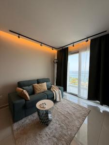 a living room with a blue couch and a table at SEAFRONT 1BDR, Panoramic views, central Marina in Limassol