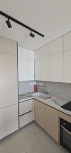 a kitchen with white cabinets and a sink at SEAFRONT 1BDR, Panoramic views, central Marina in Limassol