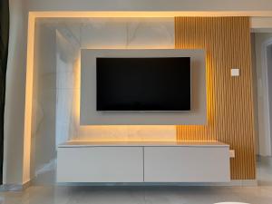 a tv on a wall with a white entertainment center at SEAFRONT 1BDR, Panoramic views, central Marina in Limassol