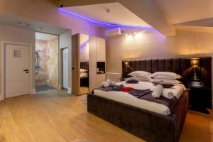a large bedroom with a large bed with purple lighting at Crystal Luxury in Craiova