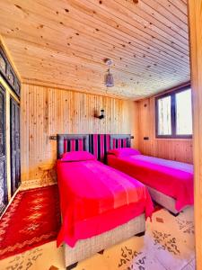 two beds in a room with wooden walls at Atlas Chalet Armed in Imlil +58 photos