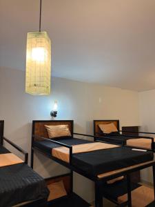 three bunk beds in a room with a light at The Layover Hostel in Katunayaka