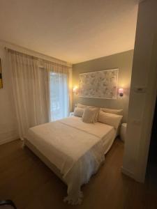 a bedroom with a bed with white sheets and a window at Guest house Festinalente in Montegrotto Terme