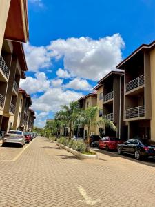 a cobblestone street with palm trees and buildings at Imaani Homes - 2A at JAK Royale in Apenkwa