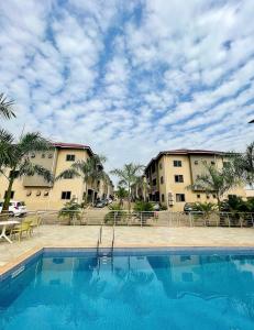 a swimming pool in front of two apartment buildings at Imaani Homes - 2A at JAK Royale in Apenkwa