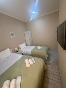 a hotel room with two beds and a flat screen tv at Hotel Blue sky in Tbilisi City