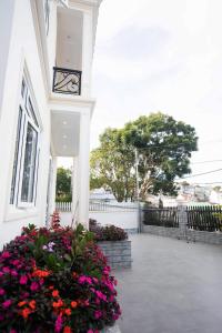 a clock on the side of a building with flowers at HUNA's HOUSE in Da Thanh