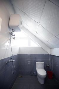 a bathroom with a white toilet and a light at HUNA's HOUSE in Da Thanh