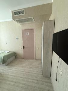 a room with a bed and a pink door at Hotel Blue sky in Tbilisi City