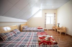a attic room with two beds and a couch at HUNA's HOUSE in Da Thanh +16 photos