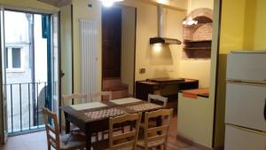 una cucina con tavolo, sedie e frigorifero di Casa Betta & Colombo a Perugia