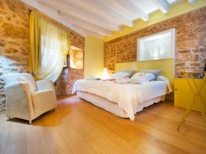 a bedroom with a large bed and a chair at Cas Ferrer Nou Hotelet in Alcudia
