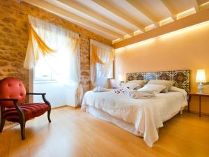 a bedroom with a bed and a chair and a window at Cas Ferrer Nou Hotelet in Alcudia
