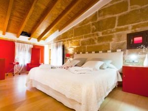 a bedroom with a large white bed in a stone wall at Cas Ferrer Nou Hotelet in Alcudia