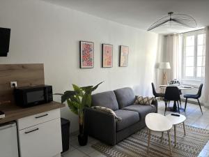 a living room with a couch and a table at L'Ecrin Léopold - Centre ville in Montélimar