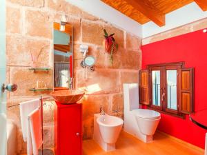 a red bathroom with a toilet and a sink at Cas Ferrer Nou Hotelet in Alcudia
