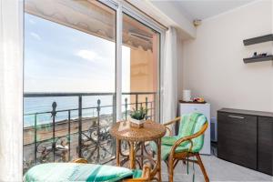 a balcony with a table and chairs and a view of the ocean at Victoria bilocale centro città e vista mare in Menton