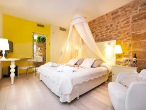 a bedroom with a bed and a table and chairs at Cas Ferrer Nou Hotelet in Alcudia