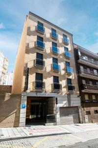 a tall building with blue windows on a street at Itaca Salamanca by Soho Boutique in Salamanca