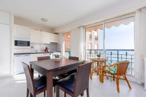 a kitchen with a table and chairs and a view of the ocean at Victoria bilocale centro città e vista mare in Menton