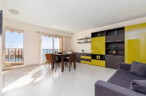 a living room with a table and yellow cabinets at Victoria bilocale centro città e vista mare in Menton +10 photos