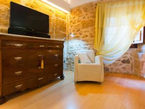 a bedroom with a dresser with a tv and a chair at Cas Ferrer Nou Hotelet in Alcudia