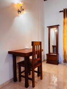 a wooden table and chair in a room with a light at The Layover Hostel in Katunayaka