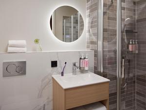 a bathroom with a sink and a shower at Numa Rotterdam Coolsingel in Rotterdam