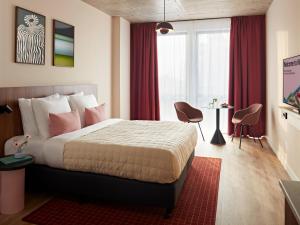 a bedroom with a large bed with red curtains at Numa Rotterdam Coolsingel in Rotterdam +34 photos