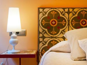 a bedroom with a bed and a lamp on a table at Cas Ferrer Nou Hotelet in Alcudia