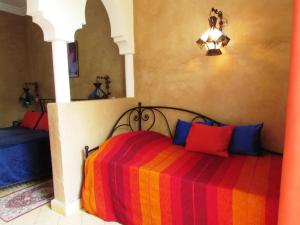 a bedroom with a bed with a colorful blanket at Le Jardin Des Epices in Taroudant