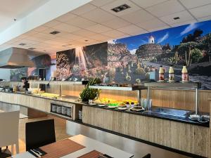 a restaurant kitchen with a large mural on the wall at Hotel Pocillos Playa, solo Adultos in Puerto del Carmen