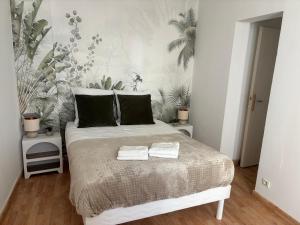 a bedroom with a bed with two towels on it at L'Ecrin Léopold - Centre ville in Montélimar