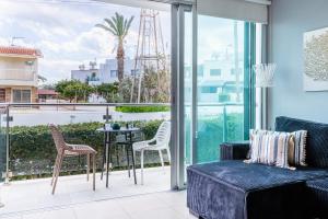 a living room with a couch and chairs on a balcony at 1BR Apt. next to Coralli Beach Protaras in Paralimni