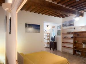 a bedroom with a yellow bed and a television at Casa dell'Artista - HelloElba in Portoferraio +23 photos